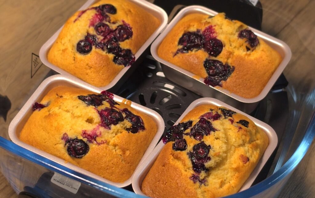Mini blueberry cakes baked golden in loaf pans inside the air fryer basket