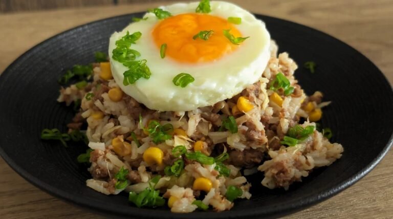 Air fryer soy garlic beef and cabbage rice bowl topped with a fried egg and spring onion