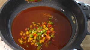 Diced bell peppers simmering in the gochujang glaze