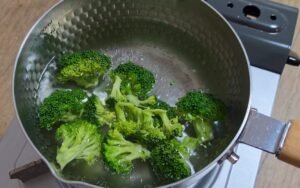 Blanching broccoli florets in a pot of boiling water
