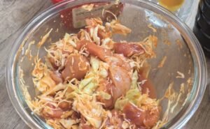 Cubed chicken and shredded cabbage mixed in gochujang marinade