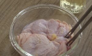 Chicken thigh marinating in sake and ginger