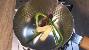 Ginger and spring onion in a pot for the poaching liquid