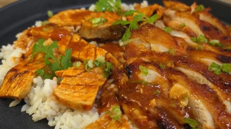 Sliced gochujang chicken with king oyster mushrooms over rice, topped with spring onion