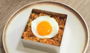 Gochujang chicken rice plated and topped with a fried egg