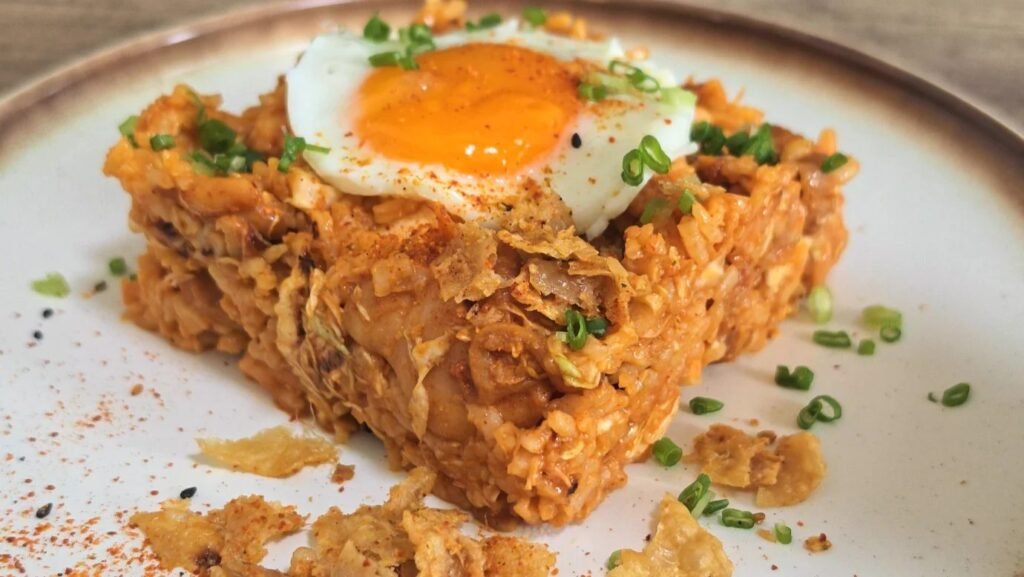 Korean gochujang chicken and cabbage rice topped with a sunny-side-up egg and crispy chicken skin