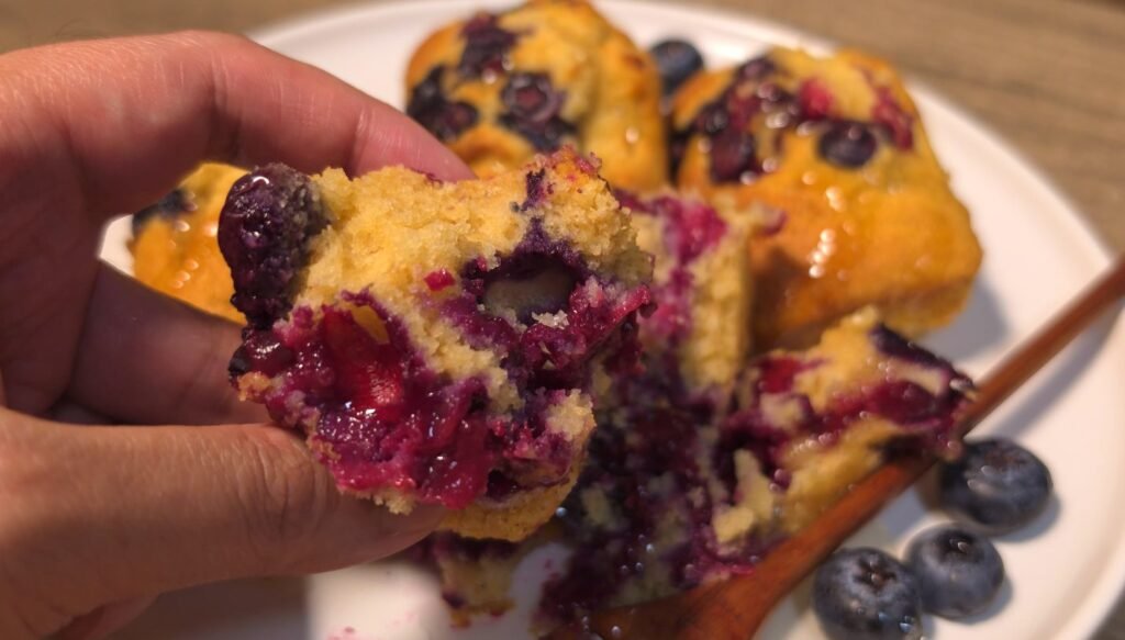 Mini blueberry cake broken open to show the soft crumb and jammy blueberries