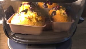 Golden mini blueberry cakes rising in loaf pans in the air fryer