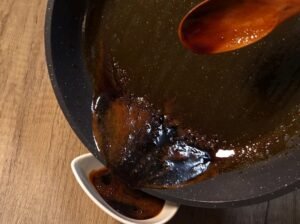 Pouring half of the teriyaki glaze into a bowl
