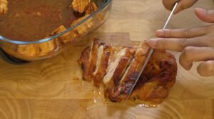 Slicing the air-fried gochujang chicken thigh into strips