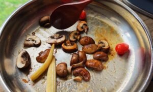 Browned Swiss brown mushrooms, baby corn and cherry tomatoes in the chicken fat
