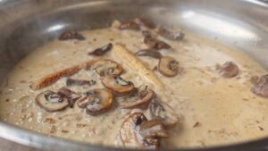 Creamy mushroom sauce simmering with chicken stock, soy sauce and heavy cream