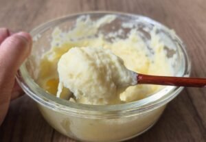 Silky mashed potatoes with butter and heavy cream on a wooden spoon