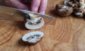 Slicing Swiss brown mushrooms in half