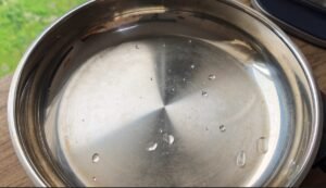 Water droplets beading on a hot stainless steel pan